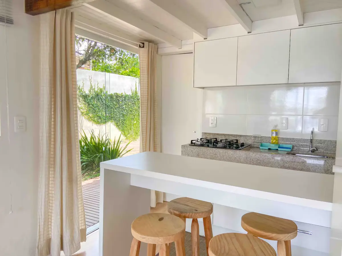 Cozinha com cooktop e bancada com banquetas