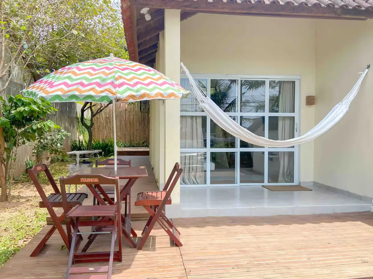 Área externa: deck com rede, guarda-sol e mesa