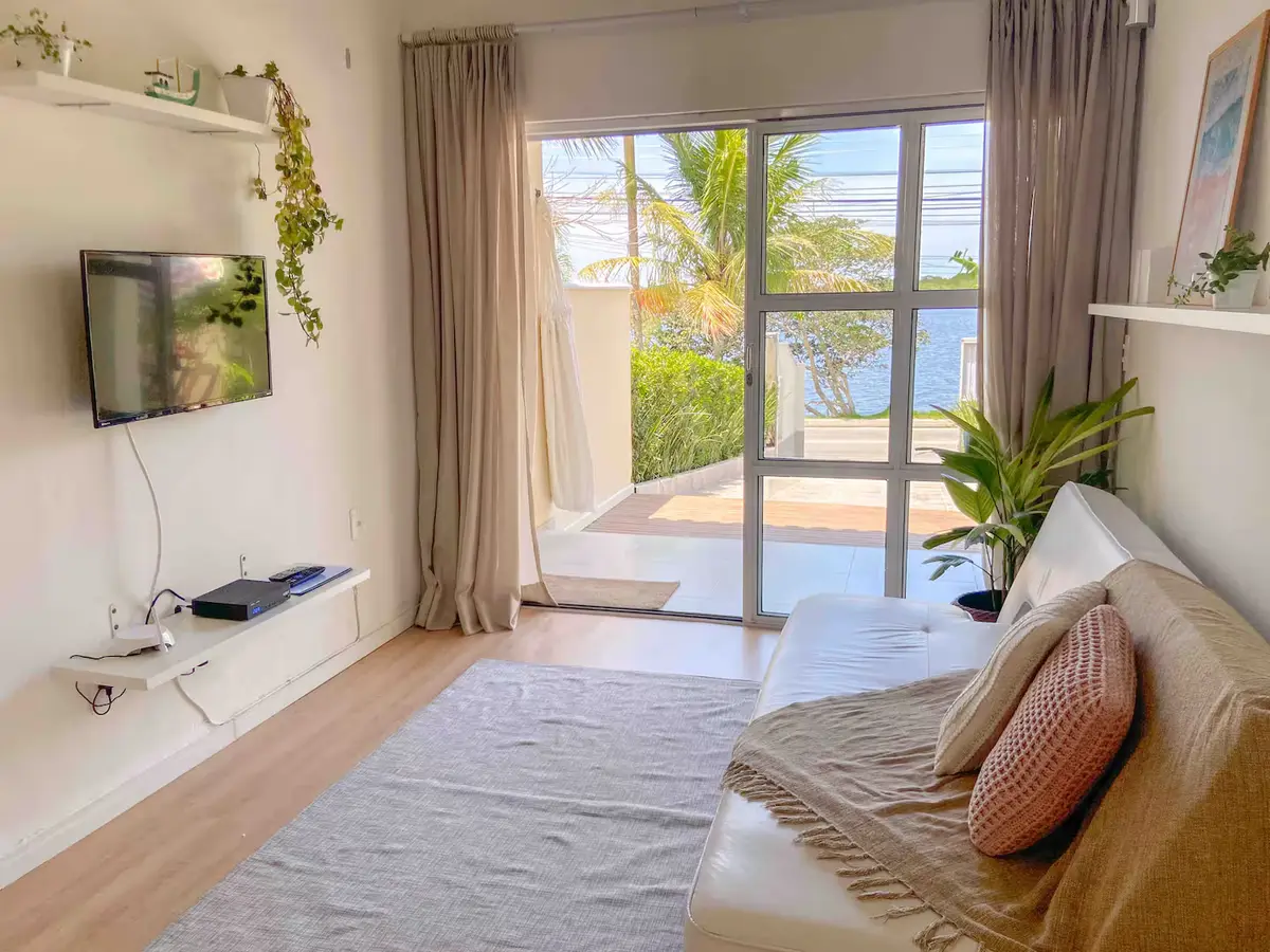 Sala com porta de vidro e vista para a lagoa